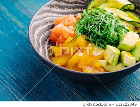 poke bowl with salmon on wood 112122349