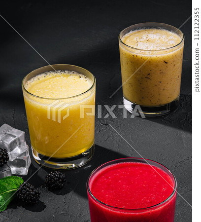 Strawberry, orange and banana smoothies on stone 112122355