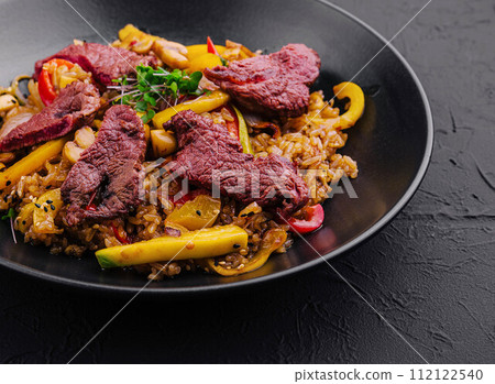 Chinese fried rice with beef on black plate 112122540