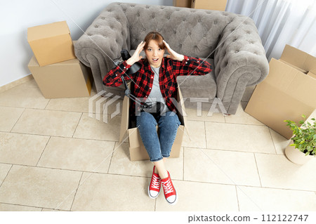 The concept of moving, a girl with boxes in an apartment. The concept of moving, a girl with boxes in an apartment. 112122747
