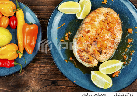 Fried salmon steak on wooden table 112122785