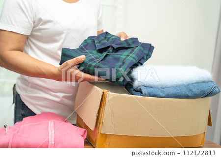 Donation box with used clothes at home to support help for poor people in the world. 112122811