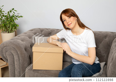 The concept of moving, a girl with boxes in an apartment. The concept of moving, a girl with boxes in an apartment. 112122898