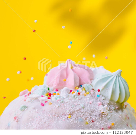easter bun with meringue on yellow background easter bun with meringue on yellow background 112123047