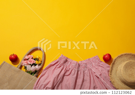 Female blouse, hat, flowers in bag and apples on yellow background, space for text Female blouse, hat, flowers in bag and apples on yellow background, space for text 112123062
