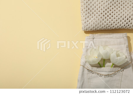 Beige clothes, jewelry and flower on light background, space for text 112123072