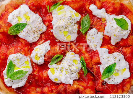 Italian pizza with mozzarella cheese and tomato topped with fresh basil Italian pizza with mozzarella cheese and tomato topped with fresh basil 112123300