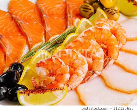 salmon, white fish, shrimps and olives close up salmon, white fish, shrimps and olives close up 112123683