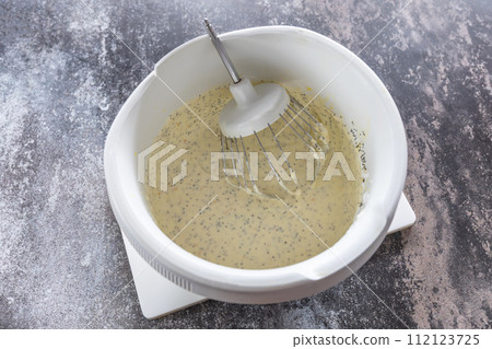 Cooking Glazed easter lemon cake decorated with confectionery and mini chocolate eggs candy on gray stone background, step by step, step 5. 112123725