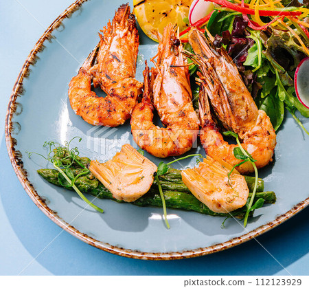 roast salmon steaks and shrimps with boiled asparagus roast salmon steaks and shrimps with boiled asparagus 112123929