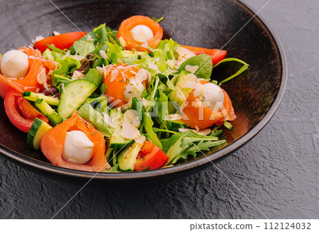 Salmon salad with mozzarella, tomato, cucumber on bowl Salmon salad with mozzarella, tomato, cucumber on bowl 112124032