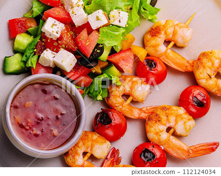 Gourmet shrimp skewers with salad greens and sauce Gourmet shrimp skewers with salad greens and sauce 112124034