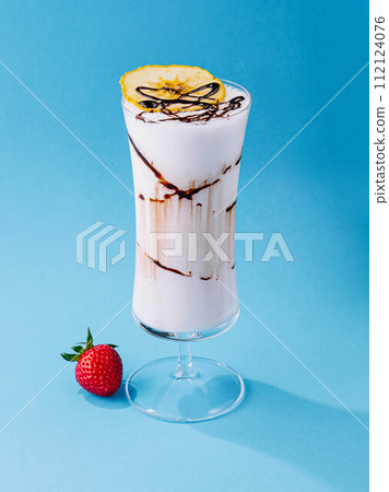 glass cup of milkshake with dry pineapple and strawberries glass cup of milkshake with dry pineapple and strawberries 112124076
