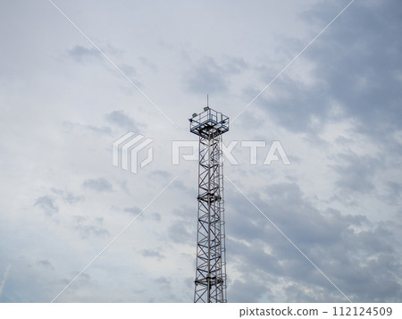 A tower at a strategic facility. Lookout tower. Thin high sentinel point with spotlights A tower at a strategic facility. Lookout tower. Thin high sentinel point with spotlights 112124509
