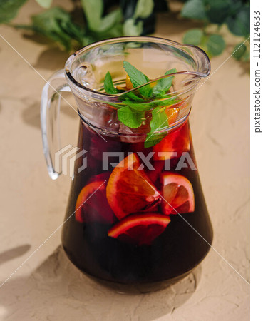 Full jug of pomegranate juice with lemon Full jug of pomegranate juice with lemon 112124633