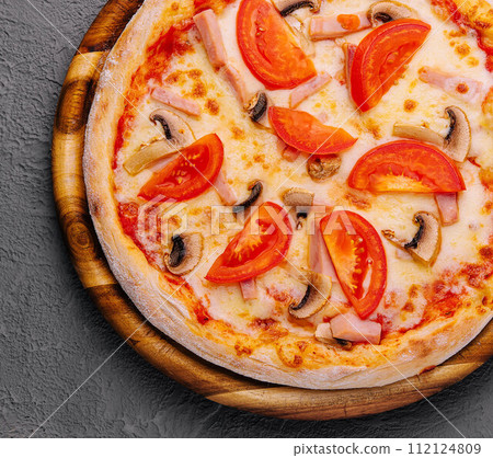 Pizza with ham, tomatoes and mushrooms on top view 112124809