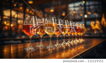 Foamy beer is in a glass on an old wooden table Foamy beer is in a glass on an old wooden table 112125551