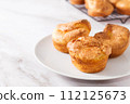 Popovers or Yorkshire pudding on a white plate on a white background, appetizer, breakfast, copy space 112125673