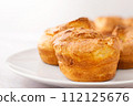 Popovers on white plate on a white background,close up. Yorkshire pudding as a easy cooking breakfast, tasty food, light snack 112125676