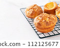 Popovers on a black pastry rack on a white background, copy space. Eggs and butter flavor, tasty snack, easy cooking breakfast. Yorkshire pudding 112125677