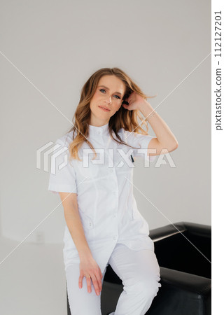 Proud professional woman doctor therapist looking at camera. Portrait of lady general practitioner wearing white coat Proud professional woman doctor therapist looking at camera. Portrait of lady general practitioner wearing white coat 112127201