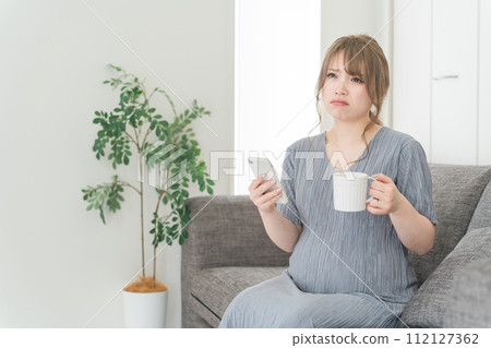 Pregnant women/maternity/premums using smartphones on the sofa at home (maternity blues/frustrated/dissatisfied) Pregnant women/maternity/premums using smartphones on the sofa at home (maternity blues/frustrated/dissatisfied) 112127362