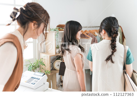 女店員在服裝店/雜貨店購物後與回家的女顧客告別 112127363