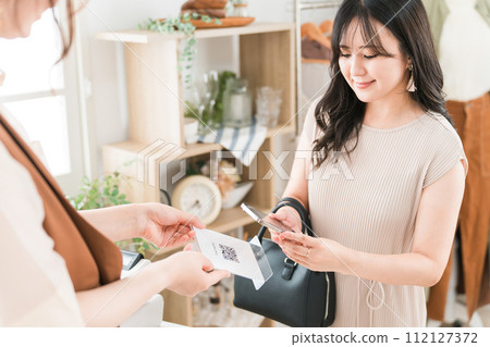 A woman and a clerk making QR code payment, electronic money, smartphone payment, and cashless payment A woman and a clerk making QR code payment, electronic money, smartphone payment, and cashless payment 112127372