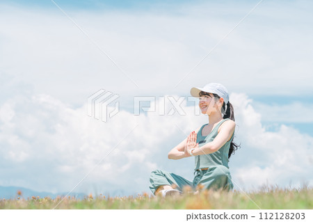 Asian woman doing yoga in the park (meditation, palms together, deep breathing, refreshment) 112128203