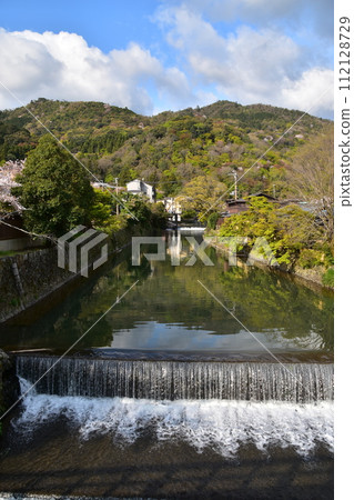日本春天的京都,嵐山周圍的街道,桂川,旅遊勝地,盛開的櫻花和美麗的新綠,河邊的老房子 日本春天的京都,嵐山周圍的街道,桂川,旅遊勝地,盛開的櫻花和美麗的新綠,河邊的老房子 112128729