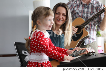 Parents play guitars, daughter on synthesizer Parents play guitars, daughter on synthesizer 112129047