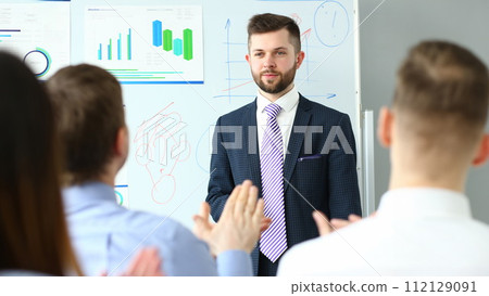 Bunch of people listening man in suit and tie telling something Bunch of people listening man in suit and tie telling something 112129091
