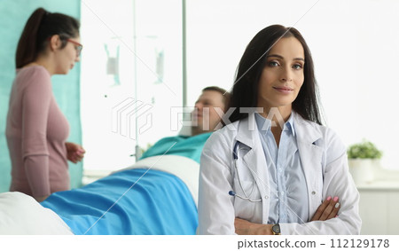 Man lies in hospital bed next to woman doctor 112129178