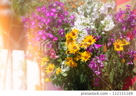 Floral background of a bouquet of chrysanthemums and petunias in a yellow haze. Floral background of a bouquet of chrysanthemums and petunias in a yellow haze. 112131189