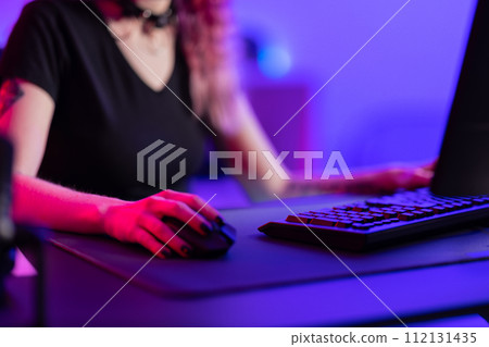 Focused Professional Gamer Playing in a Vibrant Gaming Room 112131435