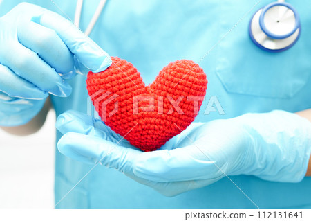Asian woman doctor holding red heart for health in hospital. Asian woman doctor holding red heart for health in hospital. 112131641