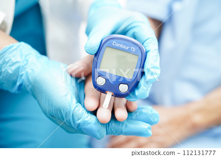 Asian doctor using digital glucose meter for check sample blood sugar level to treatment diabetes. Asian doctor using digital glucose meter for check sample blood sugar level to treatment diabetes. 112131777