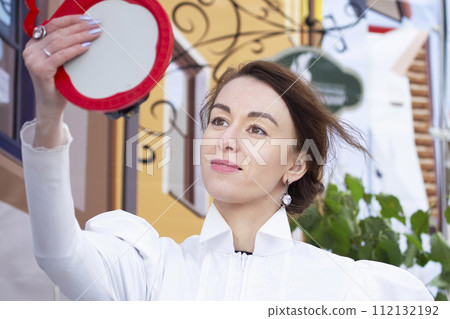 A young beautiful woman looks in the mirror and rejoices at her beauty. A young beautiful woman looks in the mirror and rejoices at her beauty. 112132192