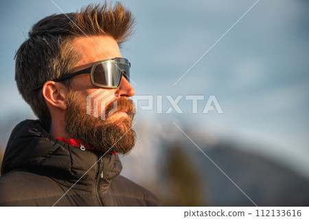 A young man with a beard and sunglasses 112133616