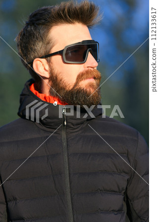 A young man with beard and sports glasses 112133617