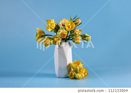 Mothers day, Greeting card. Congratulations concept, March 8. Sunlit Yellow Tulips in Vase. Close-up of vibrant yellow tulips bathed in soft natural light, emanating freshness and spring vibes. 112133804