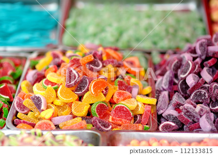 A lot of colors gummy, jelly, toffee, fudge, caramel and chocolate candies are selling in shop. Assortment of multicolored sweets as a food background. Colorful texture. A lot of colors gummy, jelly, toffee, fudge, caramel and chocolate candies are selling in shop. Assortment of multicolored sweets as a food background. Colorful texture. 112133815