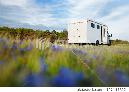 View of a large mobile home (design of van was changed during post processing ) parked in blooming meadow. Family vacation travel RV. Travel and adventure. Go everywhere 112133822