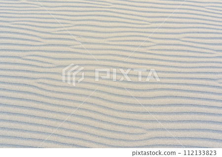 The beach with black sand. Background, texture, wavy pattern of the sand of the Adriatic Sea on Velika Plaza beach in Ulcinj, Montenegro. 112133823