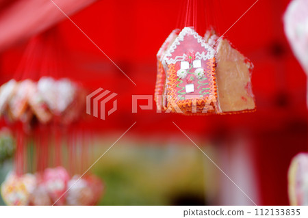 Colorful licitar gingerbreads with small mirror sold on outdoor Easter Europe holiday market. Home made sweets and cookies selling on traditional weekend fair. 112133835