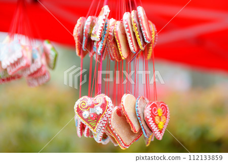 Colorful licitar gingerbreads with small mirror sold on outdoor Easter Europe holiday market. Home made sweets and cookies selling on traditional urban weekend fair. 112133859