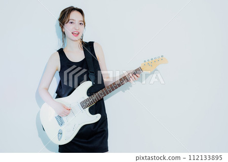 A woman playing an electric guitar A woman playing an electric guitar 112133895