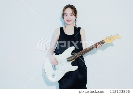 A woman playing an electric guitar A woman playing an electric guitar 112133896