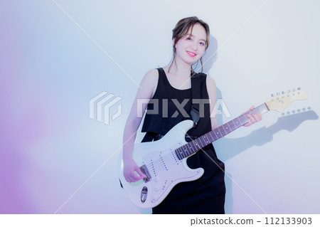 A woman playing an electric guitar A woman playing an electric guitar 112133903
