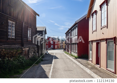 A sunlit street in Roros showcases colorful wooden facades and peaceful urban scenery 112134130